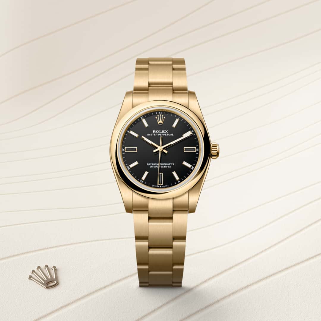 La esfera presenta índices de piedra natural situada a las 3, 6 y 9 horas. Los tonos creados para la gama Oyster Perpetual presentan en un principio forma de laca que ha de aplicarse con precisión y de forma regular con el fin de obtener una superficie uniforme. La operación se realiza en un entorno con atmósfera controlada para evitar cualquier mota de polvo o impureza. Una tras otra, seis capas de laca se depositan sobre el disco de latón que conforma la base de la esfera. A continuación se aplica un barniz antes del pulido, para conferirle al color todo su brillo y luminosidad. Posteriormente se tampografían las distintas inscripciones, mientras que los índices y la corona se remachan a mano. Resplandeciente e impecable, la esfera está lista entonces para su montaje sobre el movimiento durante el ensamblaje del reloj.