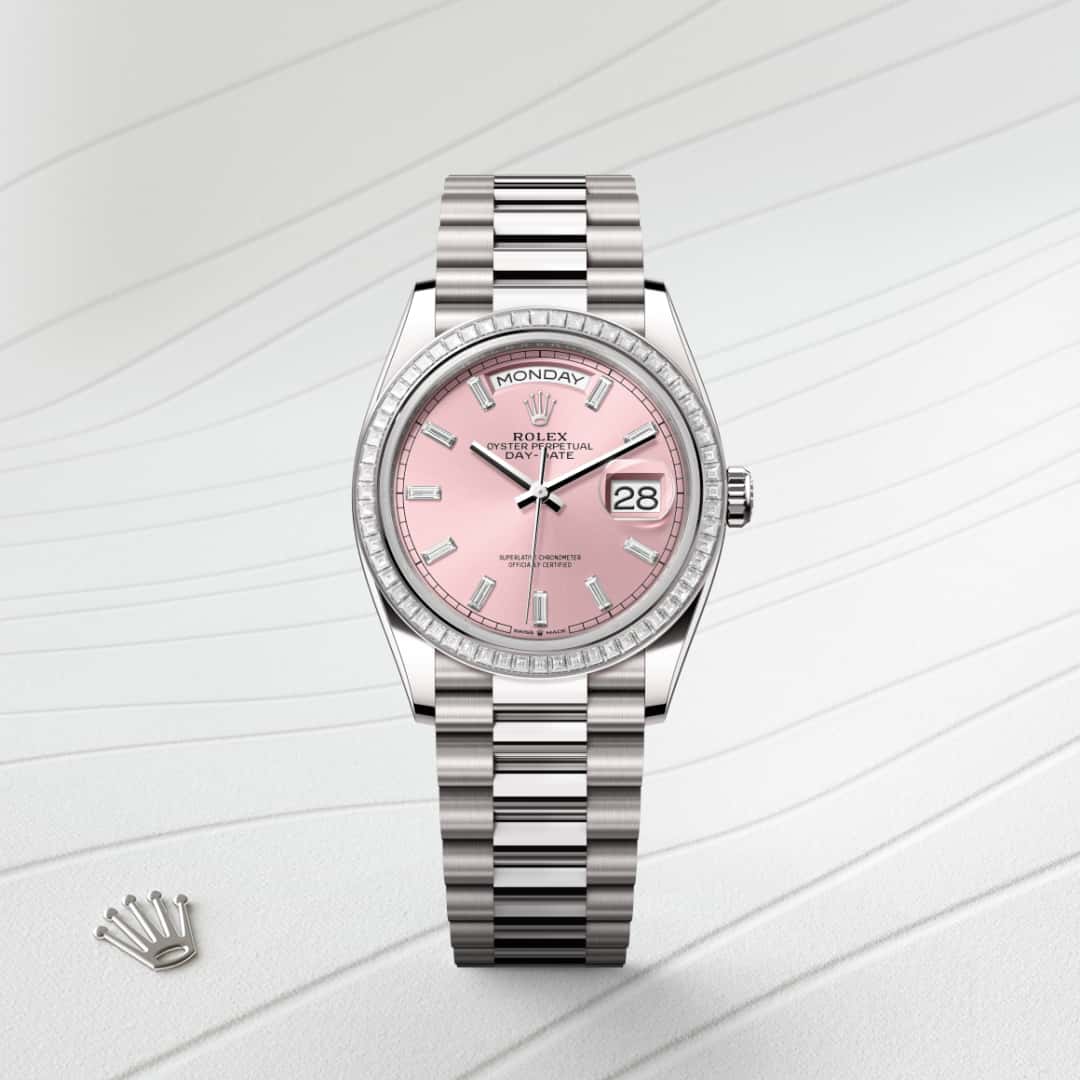 Esta esfera presenta 10 diamantes talla «baguette». El acabado tipo sol crea delicados reflejos de luz en muchas esferas de la colección Oyster Perpetual. Se obtiene utilizando técnicas magistrales de cepillado que crean surcos que salen del centro de la esfera. La luz se difunde constantemente a lo largo de cada grabado, creando un sutil brillo característico que se mueve según la posición de la muñeca. Una vez completado el acabado tipo sol, el color de la esfera se aplica mediante PVD (Physical Vapour Deposition) o galvanoplastia. Una ligera capa de barniz le da a la esfera su aspecto final. 